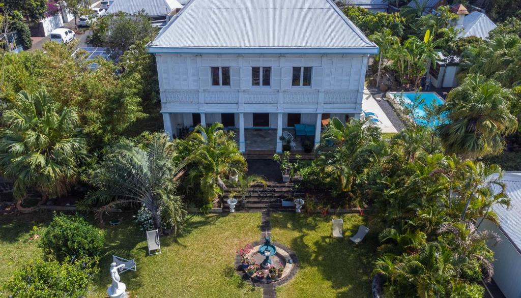 - une vue aérienne sur une maison blanche avec des palmiers dans l'établissement Villa Myriam, à Saint-Pierre