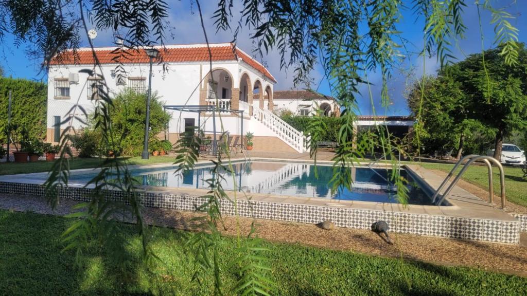 a house with a swimming pool in front of it at Los Candiles in Cantillana