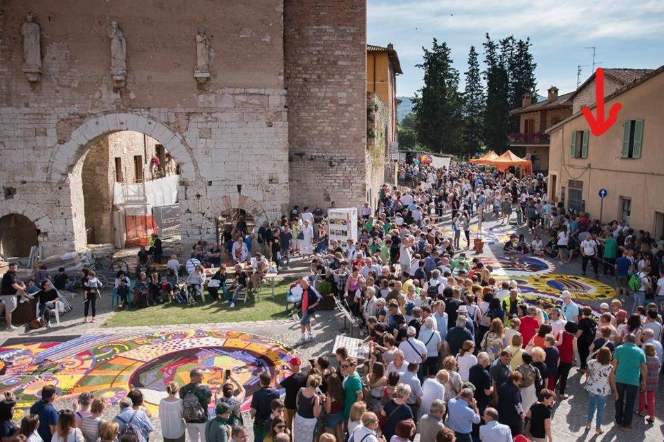 una gran multitud de personas de pie en frente de un castillo en La Fontanella, en Spello