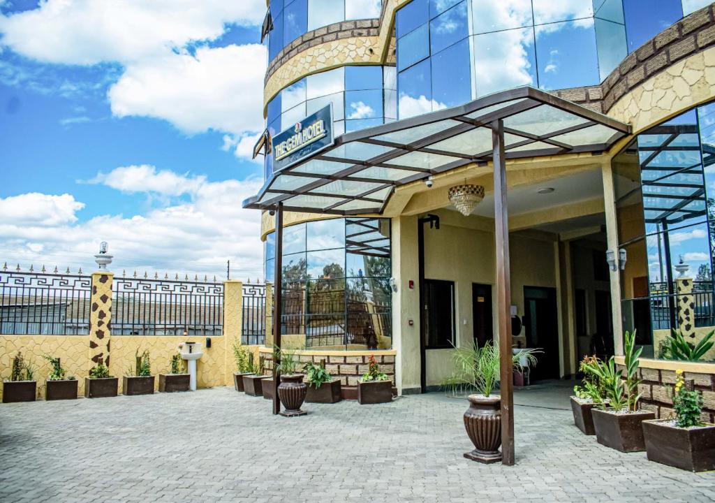 a large glass building with plants in a courtyard at THE GEM HOTEL NAIVASHA in Naivasha