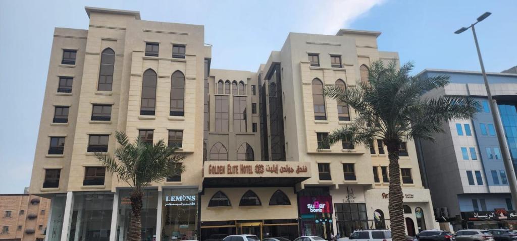 un gran edificio con palmeras delante en فندق جولدن ايليت Golden Elite Hotel en Al Khobar