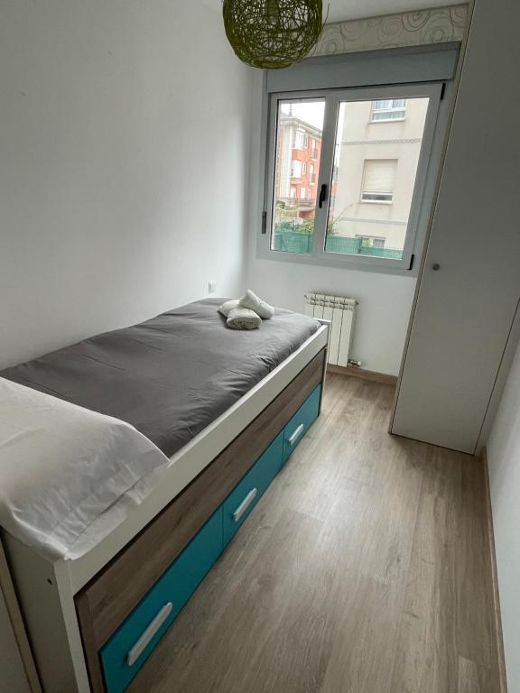 a bedroom with a large bed and a window at Piso con jardín en Liencres in Liencres