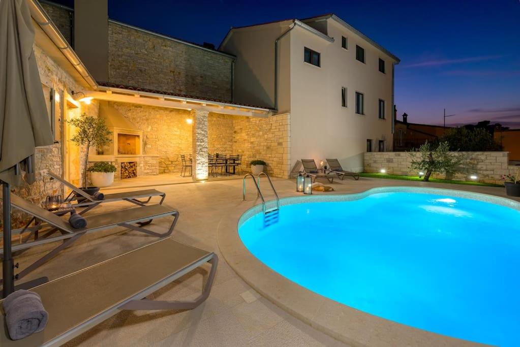 a pool in the backyard of a house at night at Villa Onelia by IstriaLux in Vodnjan