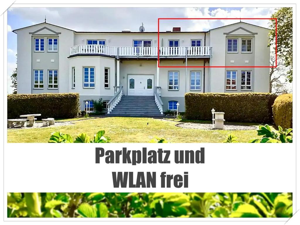 a large white house with a red rectangle at Ferienwohnung Anker Hohen Wieschendorf, ideal für Paare die Ruhe suchen in Hohen Wieschendorf