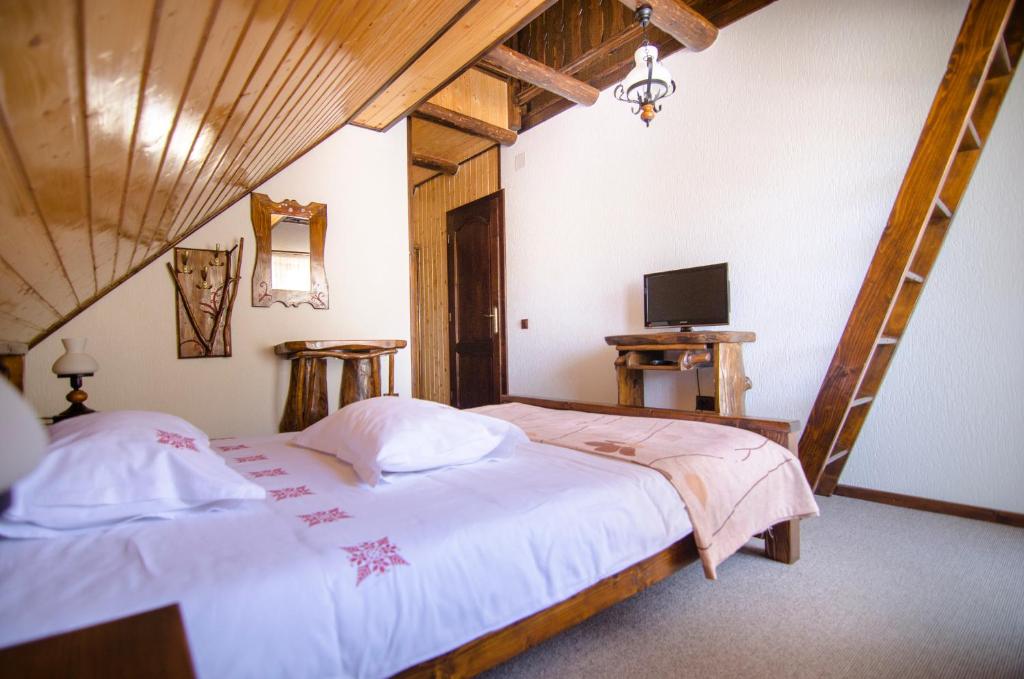 een slaapkamer met 2 bedden en een tv. bij Casa Bălan in Fundăţica