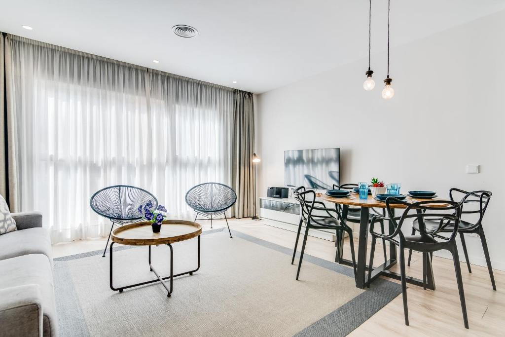 een woonkamer met een bank en een tafel en stoelen bij Smartr Las Palmas in Las Palmas de Gran Canaria