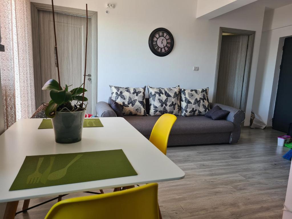 een woonkamer met een tafel en stoelen en een bank bij Luxury Apartment Mall V in Bacău