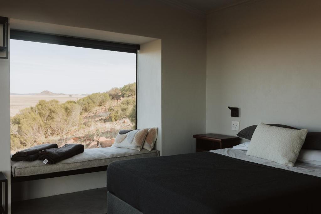 - une chambre avec 2 lits et une grande fenêtre dans l'établissement Spionkop Eco Cabin, 