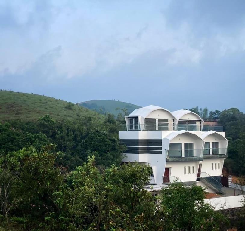 a large white building on top of a hill at Dellamore Havn in Vagamon