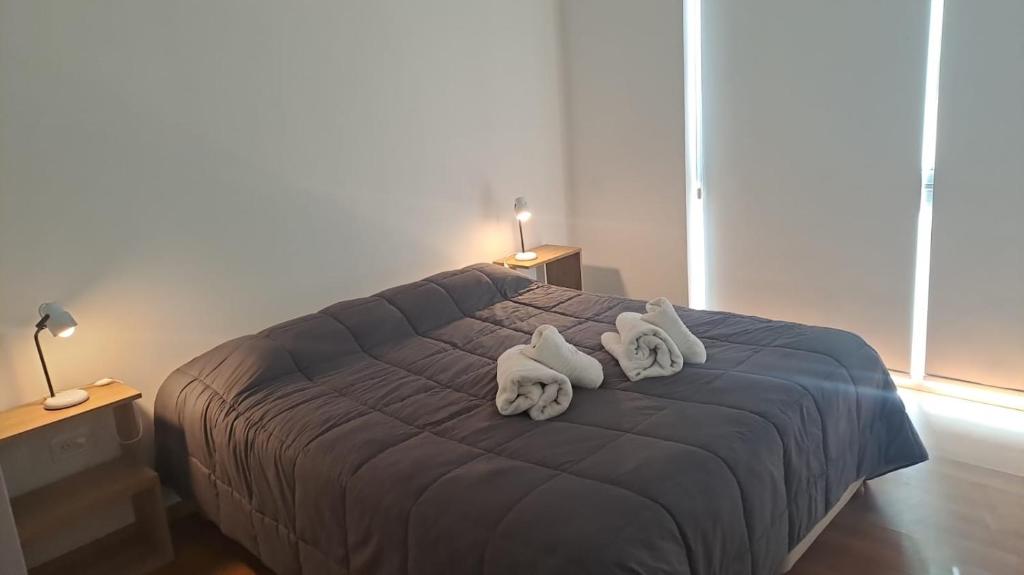 1 dormitorio con 1 cama con toallas en Minoprio 9 en El Challao