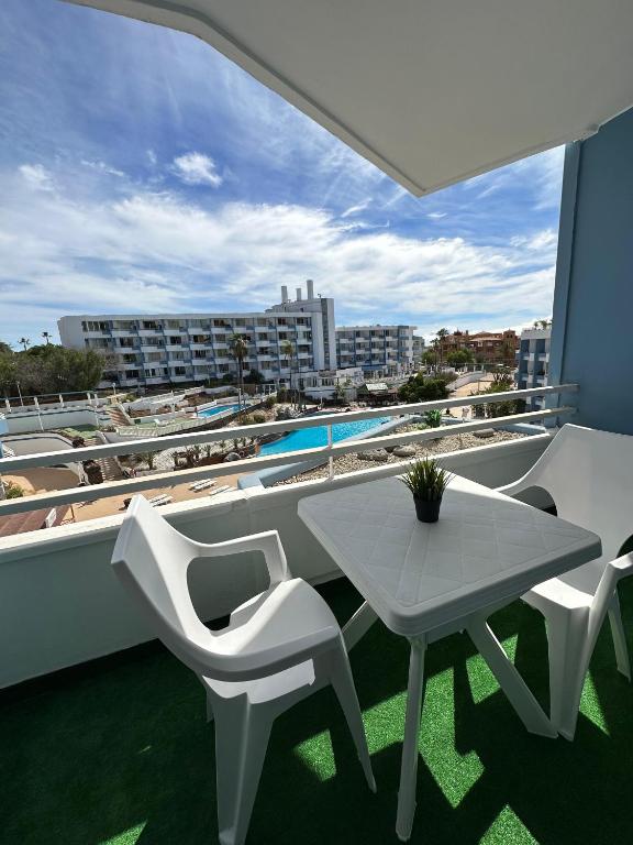 a balcony with a table and chairs and a pool at Golf del Sur Tenerife - Casa Barrera verde green park la corbeta in San Miguel de Abona