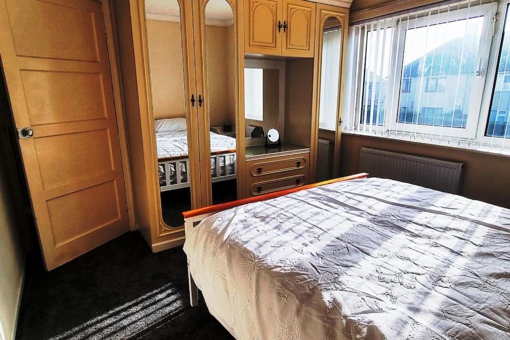 a bedroom with a bed and a dresser and a window at Relax near Wollaton Park in Nottingham