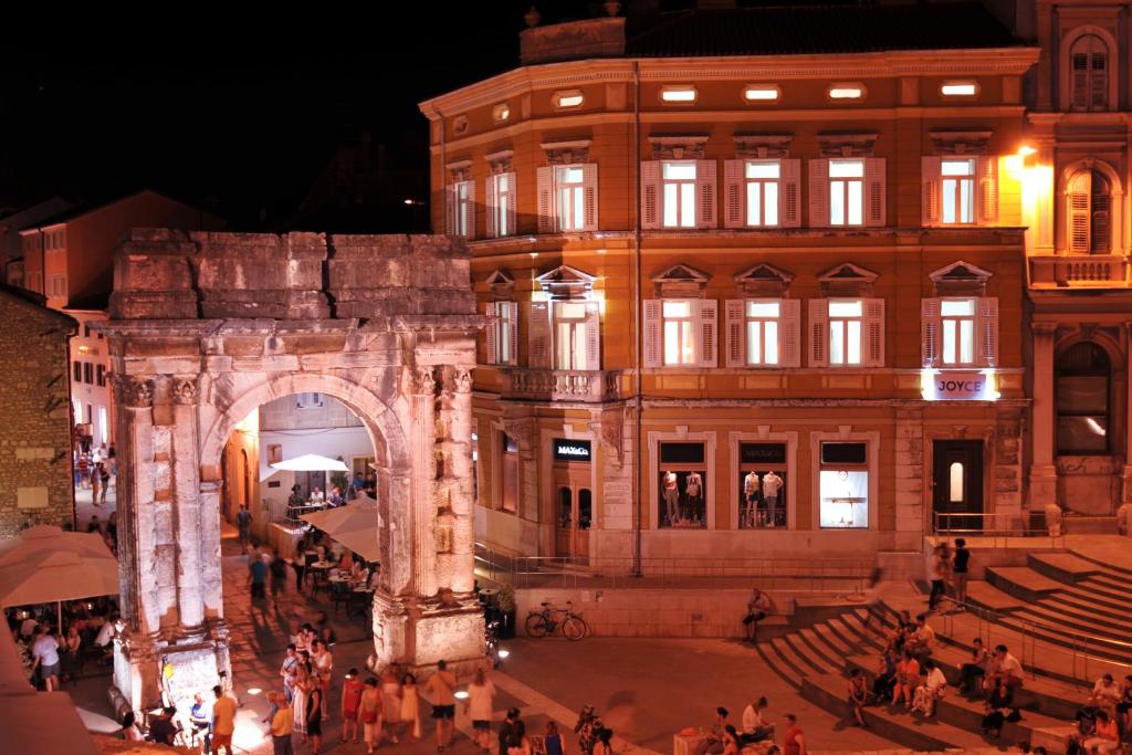 un gran edificio con un arco delante de él en Boutique Suites Joyce, en Pula