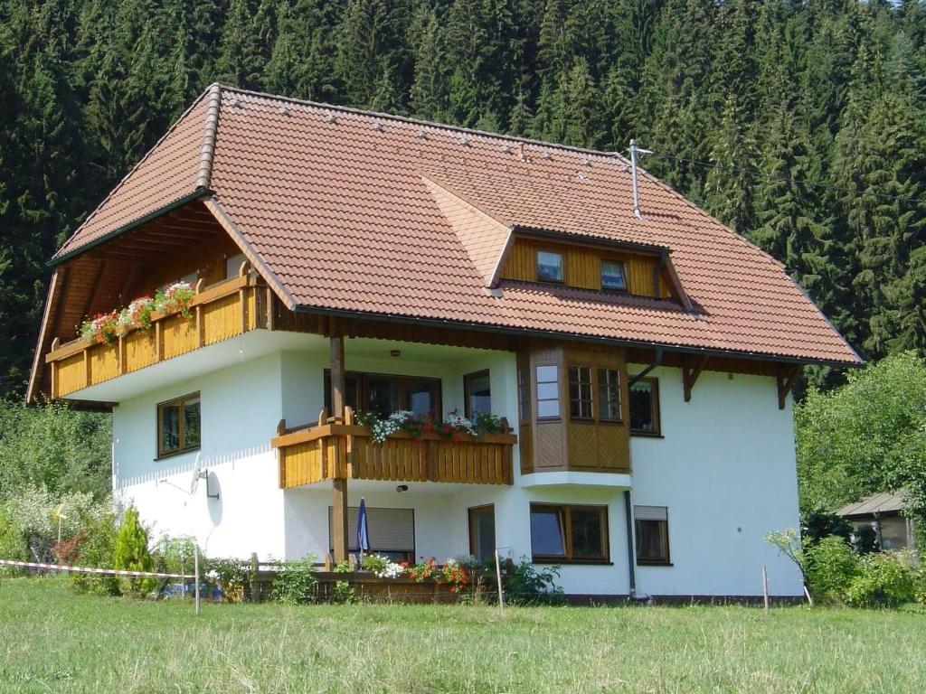 een groot wit huis met een houten balkon bij Severinenhof in Schramberg