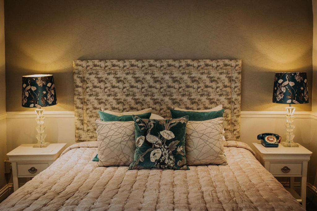 1 dormitorio con 1 cama grande y 2 lámparas en The Lake Isle Restaurant with rooms, en Uppingham