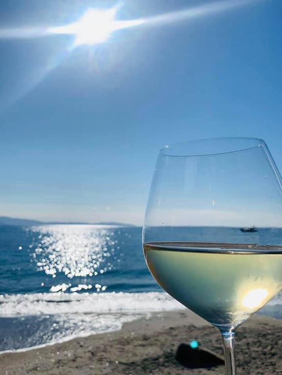 a glass of white wine sitting on the beach at Palm Beach in Ajaccio