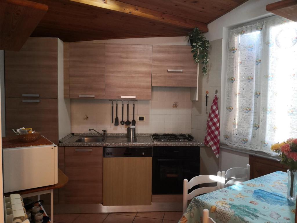 una cucina con armadi in legno, lavandino e tavolo di A due passi dal mare a Varazze