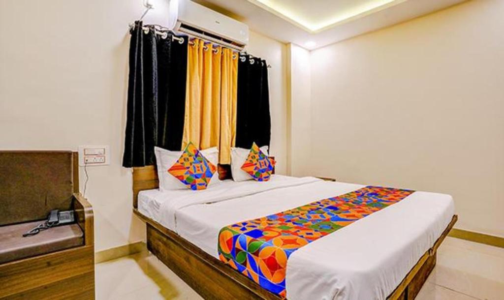 a bedroom with a bed and a window at FabHotel Royal Inn NS in Pune