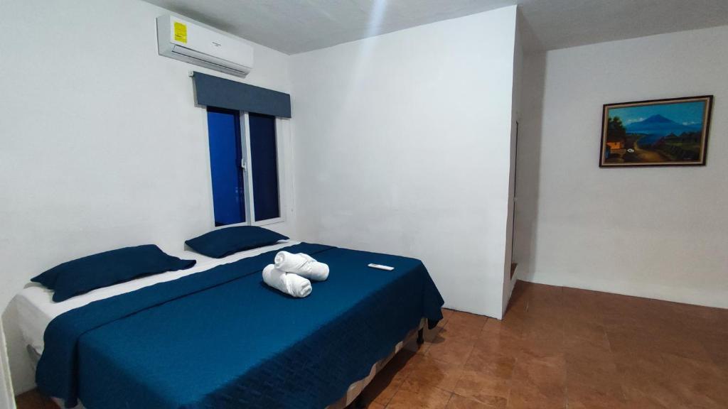 um quarto com uma cama azul com um ursinho de peluche em Apartamento Pradera's em Escuintla