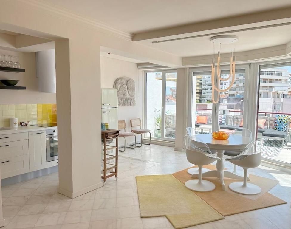 a kitchen with a glass table and chairs in a room at Groovy Caparica Gem with Large Sunny Terrace in Costa da Caparica