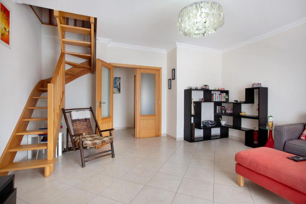 a living room with a staircase and a red couch at A O - Ferrel House Casual in Ferrel