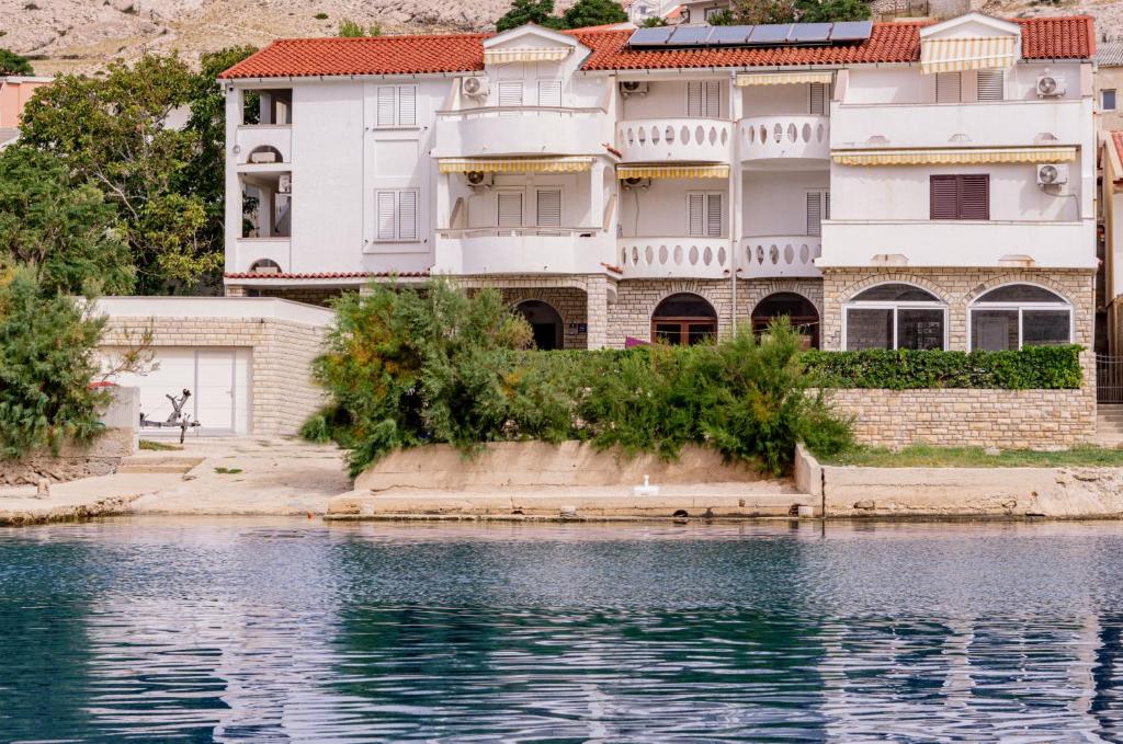 a large white building next to a body of water at Dubravko in Metajna