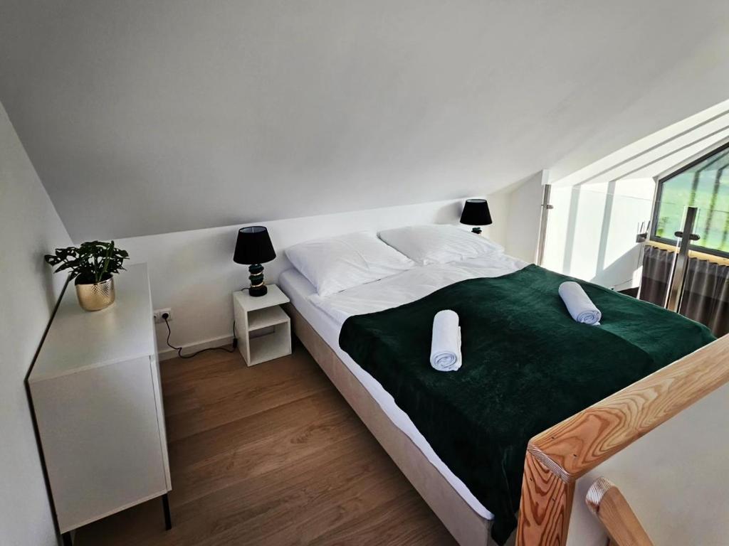 a bedroom with a large bed with a green blanket at Elizjum pod Śnieżką in Bukowiec