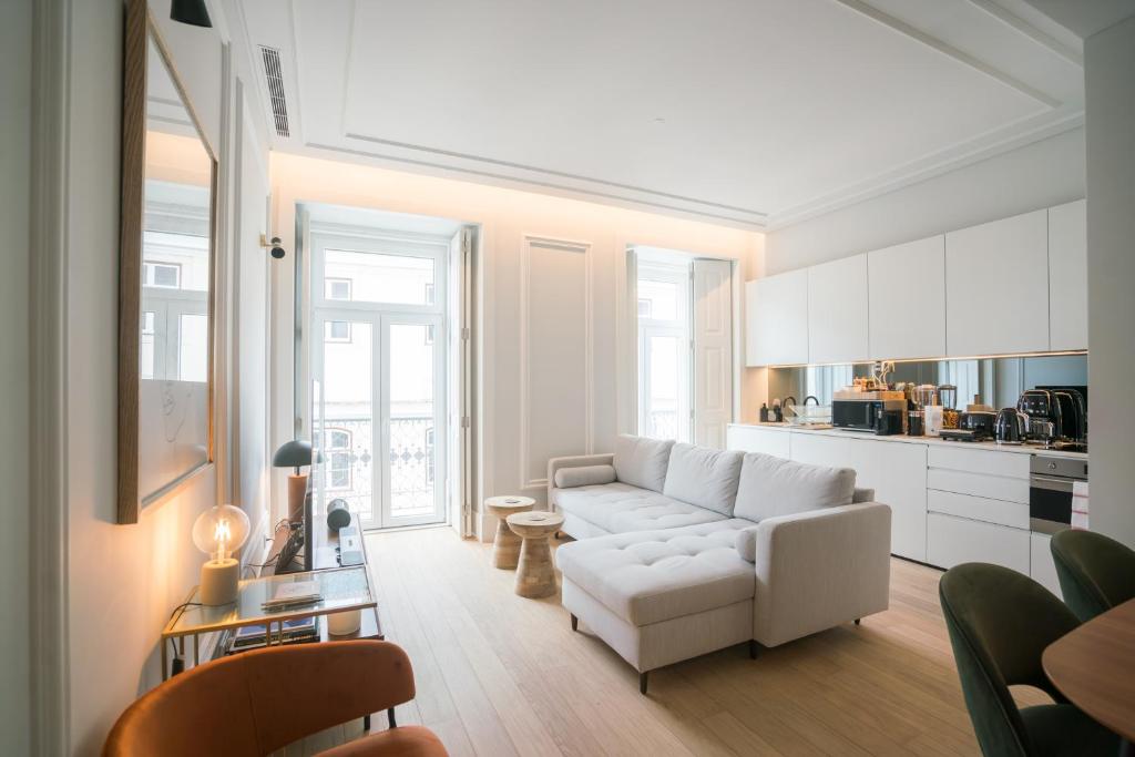 a living room with a white couch and a kitchen at Luxury condo in heart of Baixa-Chiado in Lisbon