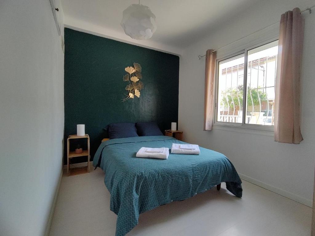 een slaapkamer met een bed met twee handdoeken erop bij Les Papillons in Perpignan