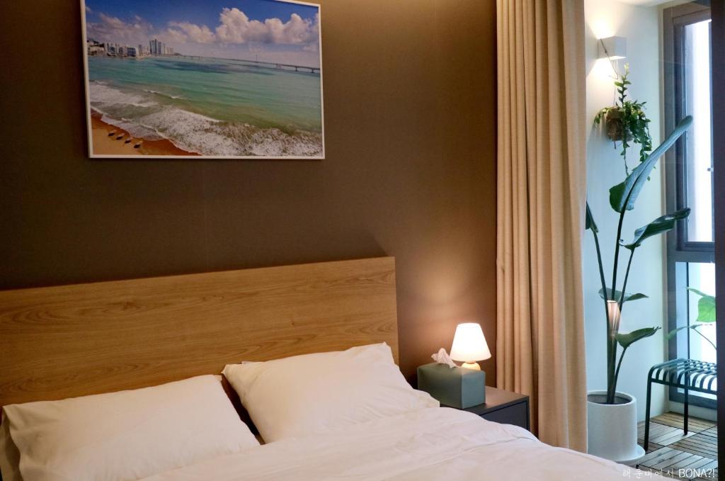 a bedroom with a bed and a view of the beach at Haeundae Bona Travel in Busan