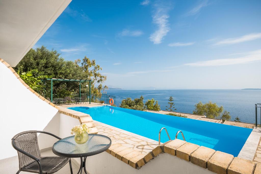 a villa with a swimming pool and a table and chairs at Four-Bedroom Villa Eleni by Konnect, with Private Pool & Stunning Seaview in Barbati