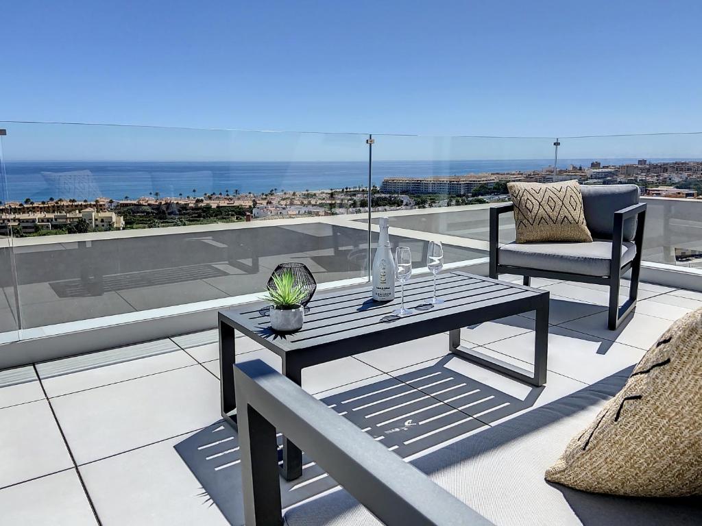 een patio met een tafel en een stoel op een dak bij Via Celere 2335 Golf & Sea view in Casares