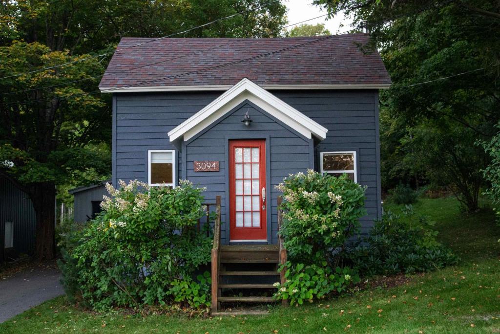 a blue tiny house with a red door in a yard at The Forester in Cedar