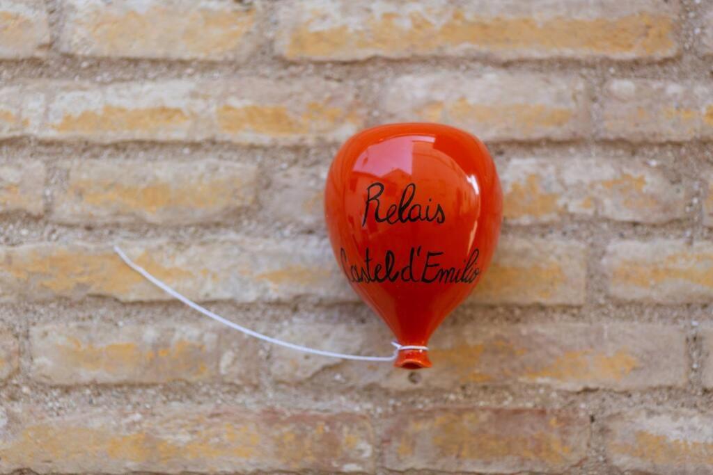 pomarańczowy balon jest przymocowany do ściany z cegły w obiekcie Relais Castel d'Emilio – Casa ARANCIO w mieście Cassero