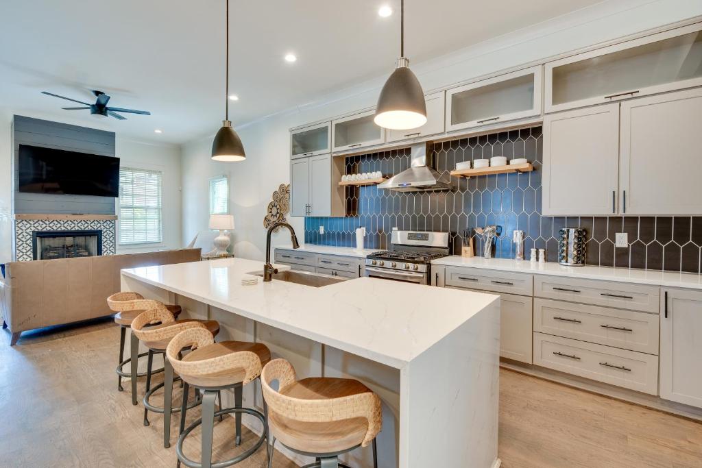 a kitchen with a large white island with bar stools at ATL Home 2 Mi to Downtown Covered Deck and Backyard in Atlanta