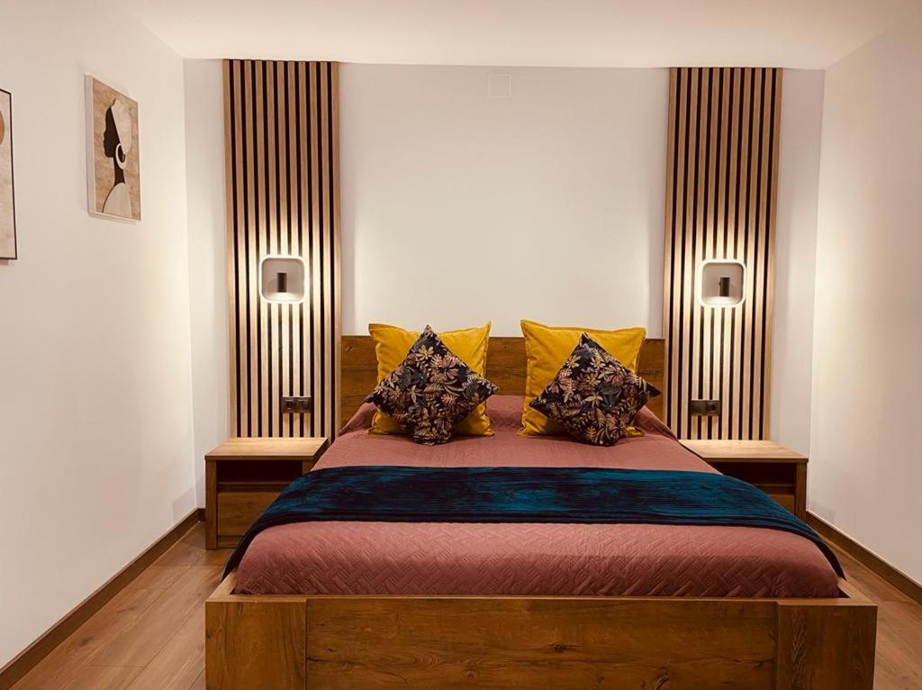 a bedroom with a large wooden bed with yellow pillows at Luxury apartament airport in Málaga