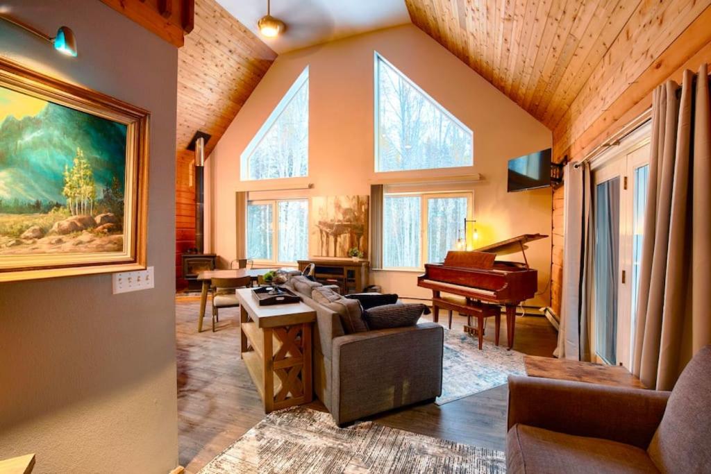 a living room with a couch and a piano at Corporate Cabin Aurora Refuge in Fairbanks