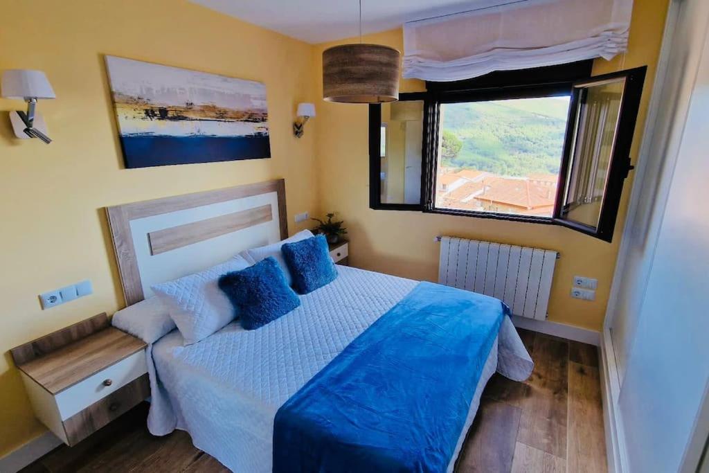1 dormitorio con cama con sábanas azules y ventana en Apartamento Rural Mi Pequeña Lulú TR-CC-00564, en Gata