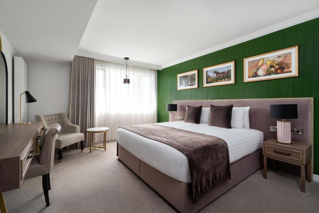 1 dormitorio con cama y pared verde en Ivanhoe Inn and Hotel, en Belfast