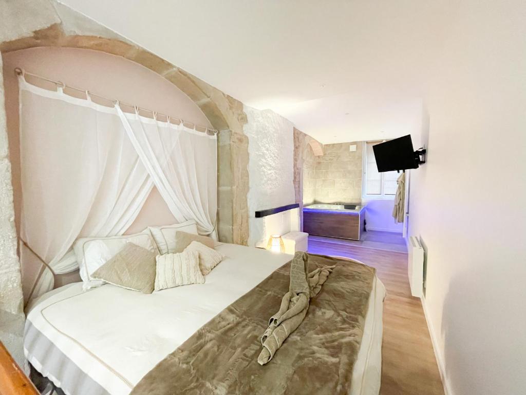 a bedroom with a large white bed in a room at La voute Doloise - Love room & spa in Dole