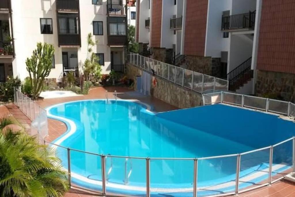 uma grande piscina azul em frente a um edifício em Casa Perla - Cerca de la playa em Playa de Santiago