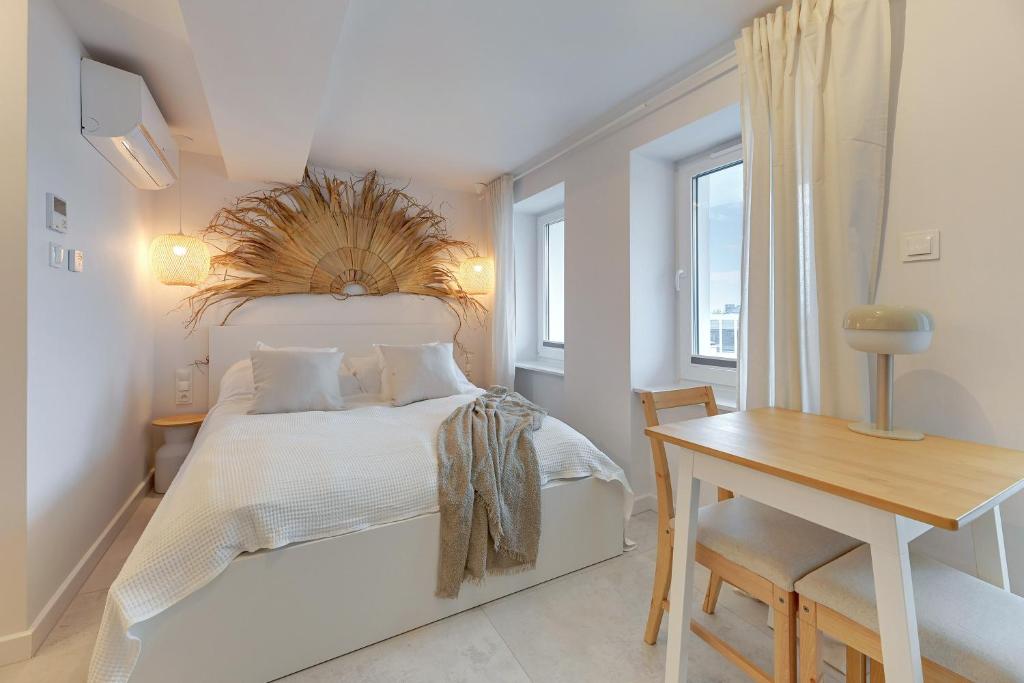 Schlafzimmer mit einem Bett, einem Schreibtisch und einem Fenster in der Unterkunft Kamień by Grand Apartments in Gdynia