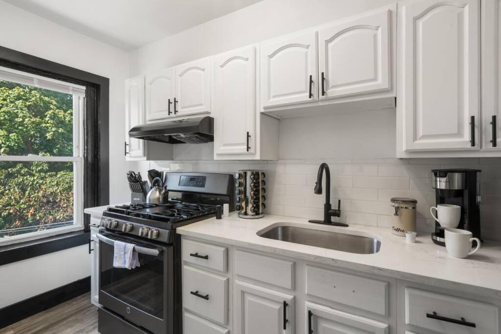 a kitchen with white cabinets and a sink at Center City Philly Home, Cozy 1-BR, Ideal Location for 4 Guests! in Philadelphia