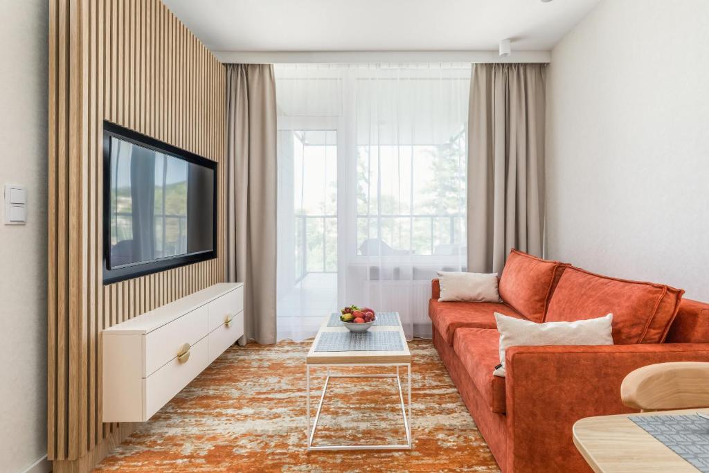 a living room with a couch and a tv at Rent like home - Bel Mare F324 in Międzyzdroje