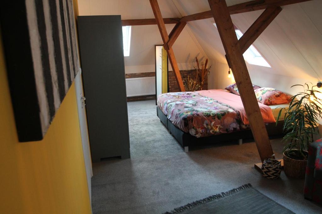 een slaapkamer met een bed op zolder bij Karin's kruidenhoeve B&B kamer Kamille met Finse sauna in Lutten