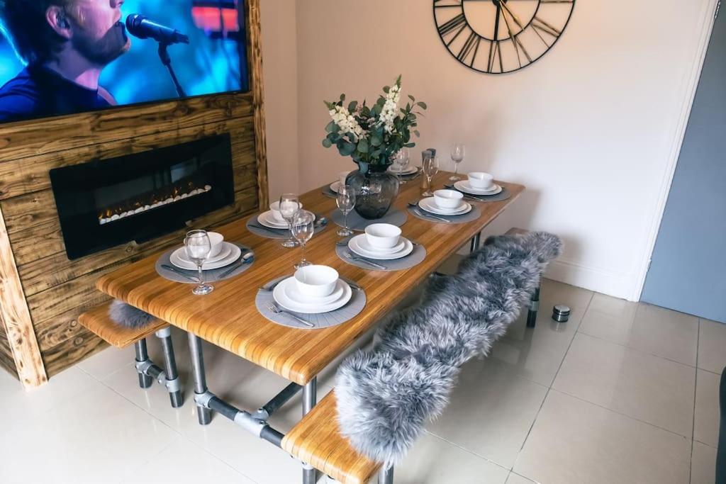 a dining room table with chairs and a television at 4 bedroom - Sleep 9 home in Cheadle Staffordshire - Alton towers Polar Express Dimmingsdale Peak District Trentham Gardens Water World in Cheadle