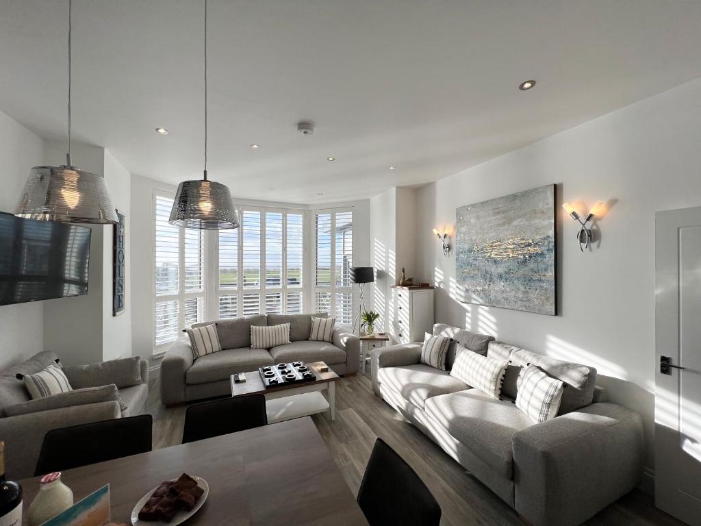 a living room with two couches and a table at St Annes Beach Apartments in Lytham St Annes