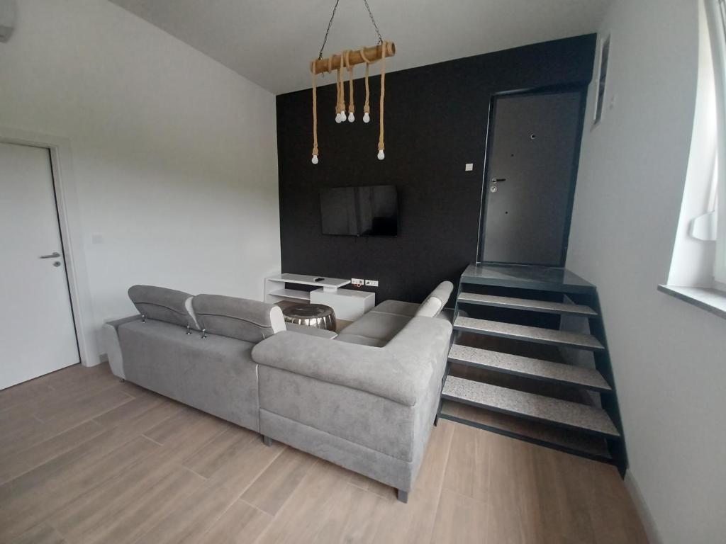 a living room with a couch and a staircase at Apartma in Izimje