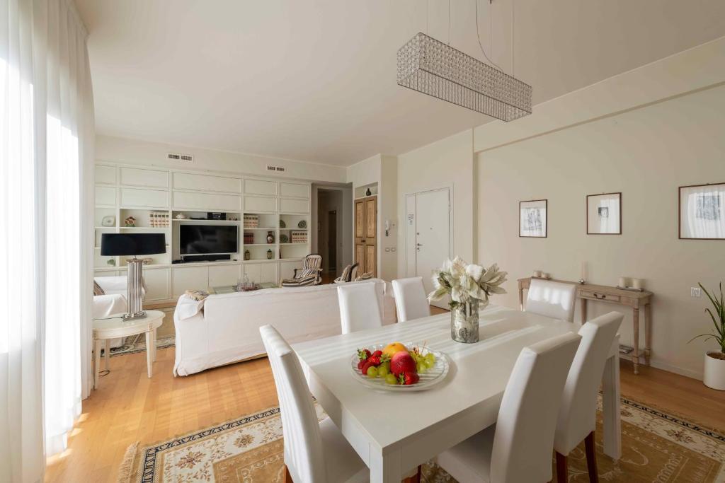 una sala da pranzo bianca con tavolo e sedie bianchi di Casa Gramsci luxury apartment a Pesaro