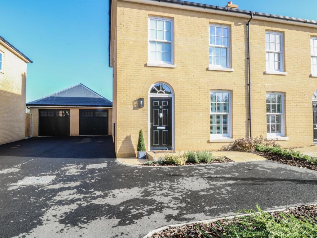 a brick house with a driveway in front of it at The Hollies in Norwich